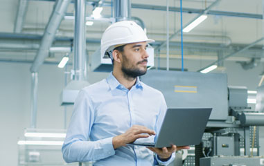 chico en fábrica con un ordenador