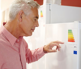 Hombre leyendo una etiqueta de eficiencia energética de un electrodoméstico