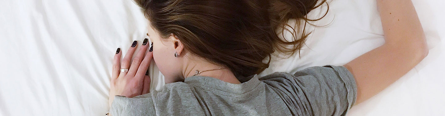 Mujer durmiendo boca abajo en una cama
