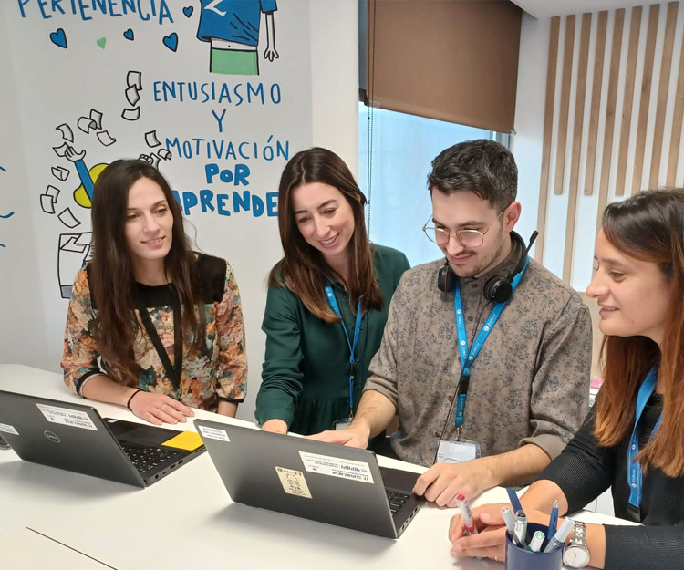 colaboradores Zurich sonrientes mirando un ordenador